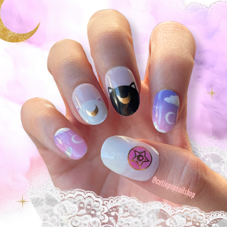 Cutie Pop Nail Shop Luna nail strips with moon and star designs on a hand displaying the nails