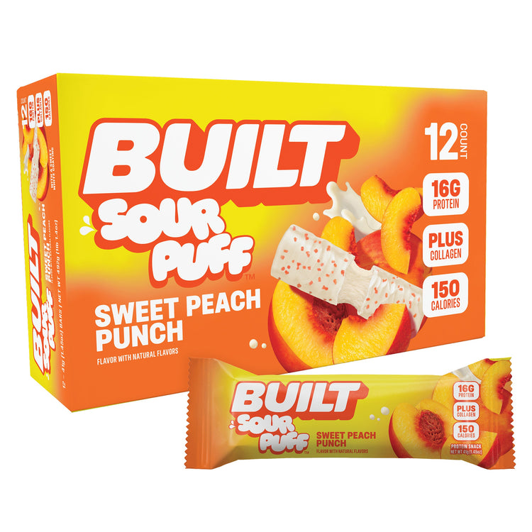 BUILT Sweet Peach Punch Sour Puffs stacked in a carton, showing peach-flavored chewy sour candy treats.