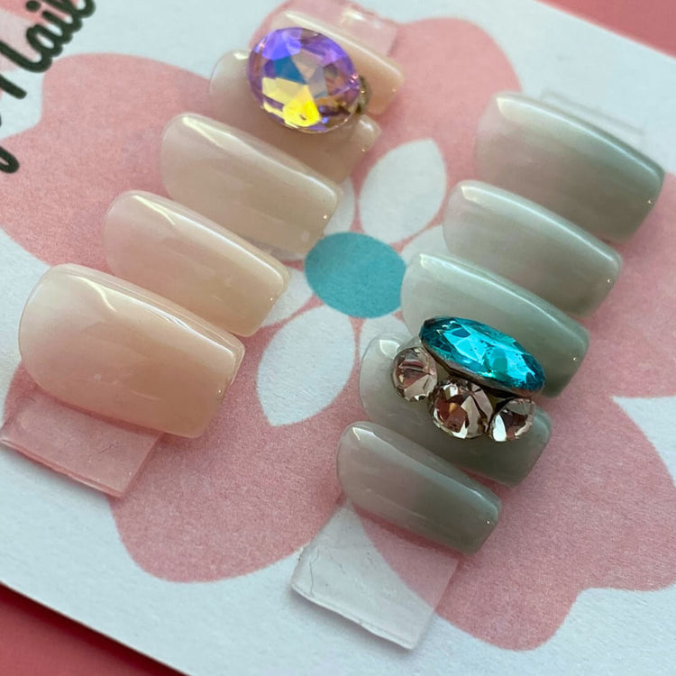 Short pastel blue press-on nails with gem accents by Cutie Pop Nail Shop, featuring a trendy, elegant design.