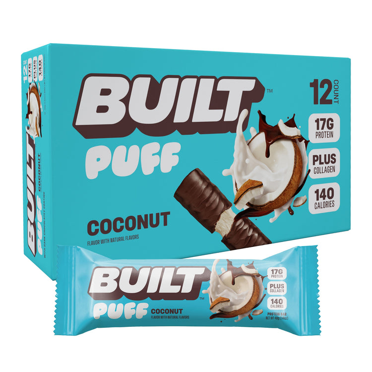 Stack of BUILT Coconut Puff snacks showing golden coconut-flavored baked puffs in a neat pile.