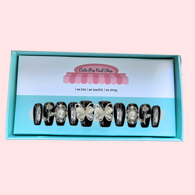 Black butterfly press on nails from Cutie Pop Nail Shop featuring elegant black designs and delicate butterfly accents.
