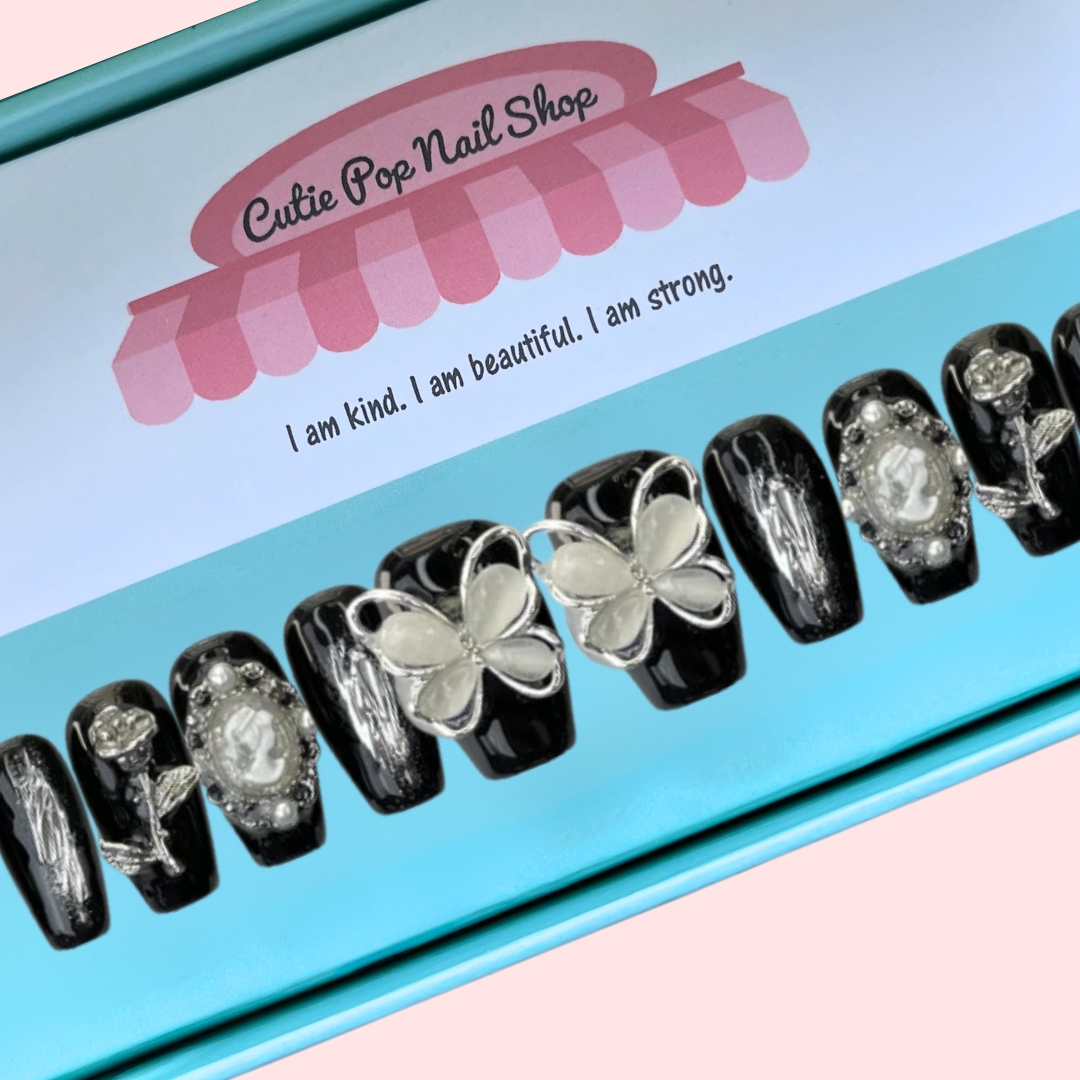 Black butterfly design press-on nails from Cutie Pop Nail Shop, showcasing a stylish black nail set with butterfly accents.