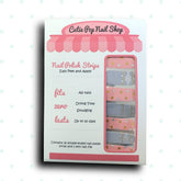 Pink and gold nail strip design from Cutie Pop Nail Shop, featuring elegant deco patterns on a close-up of the nail strips.