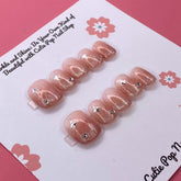 Glittery blush-colored press-on nails from Cutie Pop Nail Shop, showcasing a shiny, glamorous nail design.