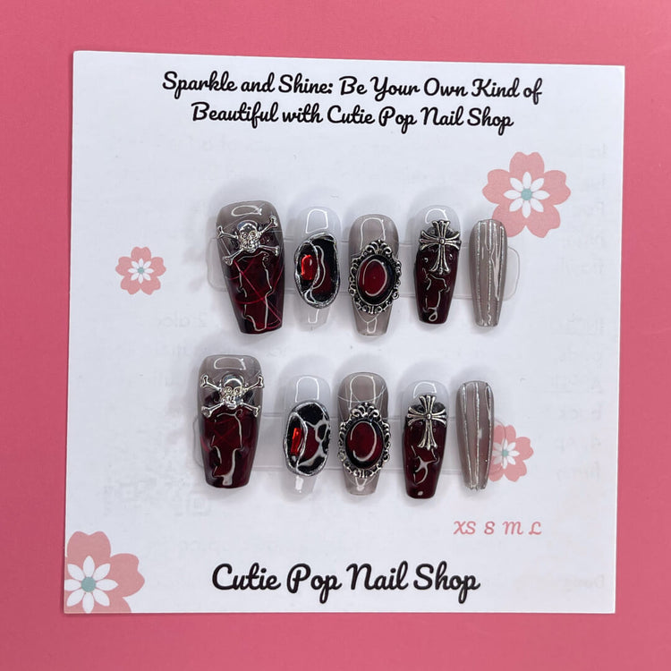 Rebel Chic press-on nails by Cutie Pop Nail Shop featuring stylish, edgy nail art with black and metallic accents.