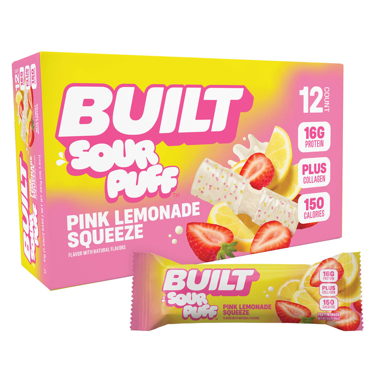 Stack of 12 BUILT Pink Lemonade Sour Puffs in a carton, showing the colorful sour candy puffs from an angled view.