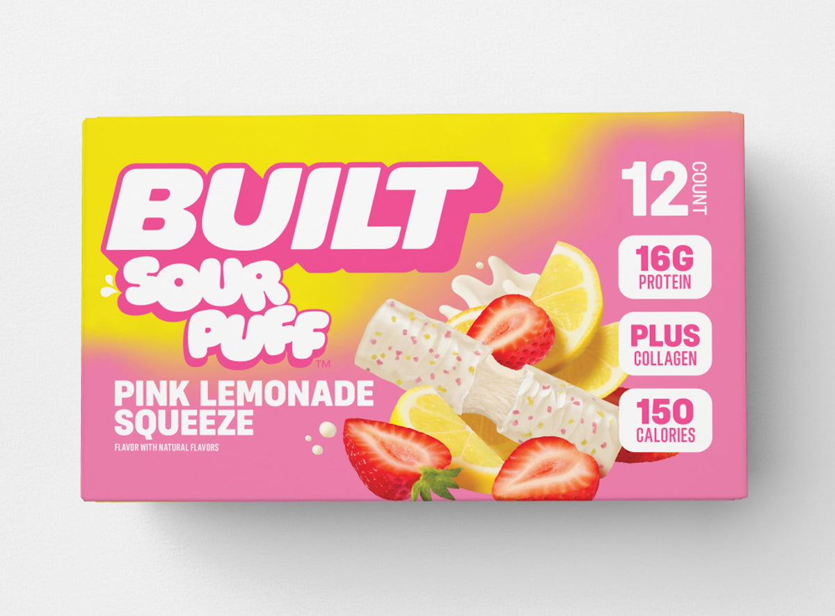 BUILT Pink Lemonade Sour Puff stack in a carton, showcasing the colorful, tangy sour candies with a pink lemonade flavor.