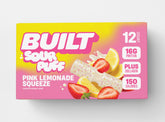 BUILT Pink Lemonade Sour Puff stack in a carton, showcasing the colorful, tangy sour candies with a pink lemonade flavor.