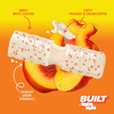 Stack of BUILT Sweet Peach Punch Sour Puffs with textured peach flavor coating and vibrant pink color.