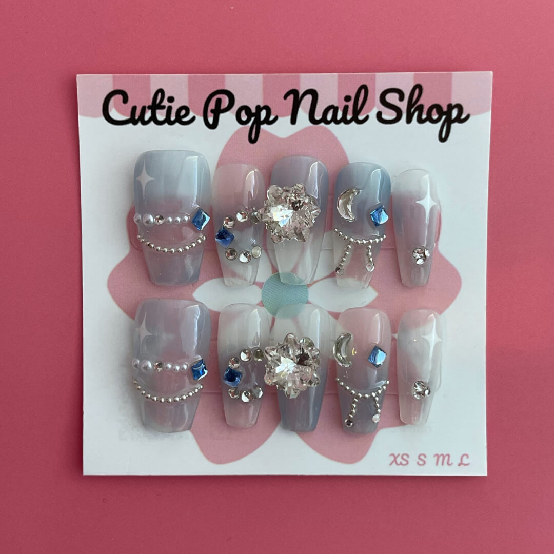 Blue Star Gem press-on nails by Cutie Pop Nail Shop featuring star-shaped designs on glossy nail tips.