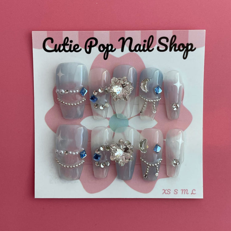 Blue Star Gem press-on nails by Cutie Pop Nail Shop featuring star-shaped designs on glossy nail tips.
