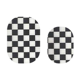 Checkered Cutie Pop Nail Shop nail strips on natural nails, featuring a bold black and white checkered pattern.