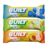Stack of BUILT Sour Puffs in a variety flavor box, showing colorful puff wrappers and a clear view of the snack packaging.