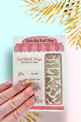 Guernsey Gold nail strips by Cutie Pop Nail Shop with shiny gold finish and intricate design, perfect for stylish manicures.
