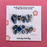 Medium coffin-shaped press-on nails with Bougie Bling 17 design by Cutie Pop Nail Shop featuring shiny, decorative nail art.