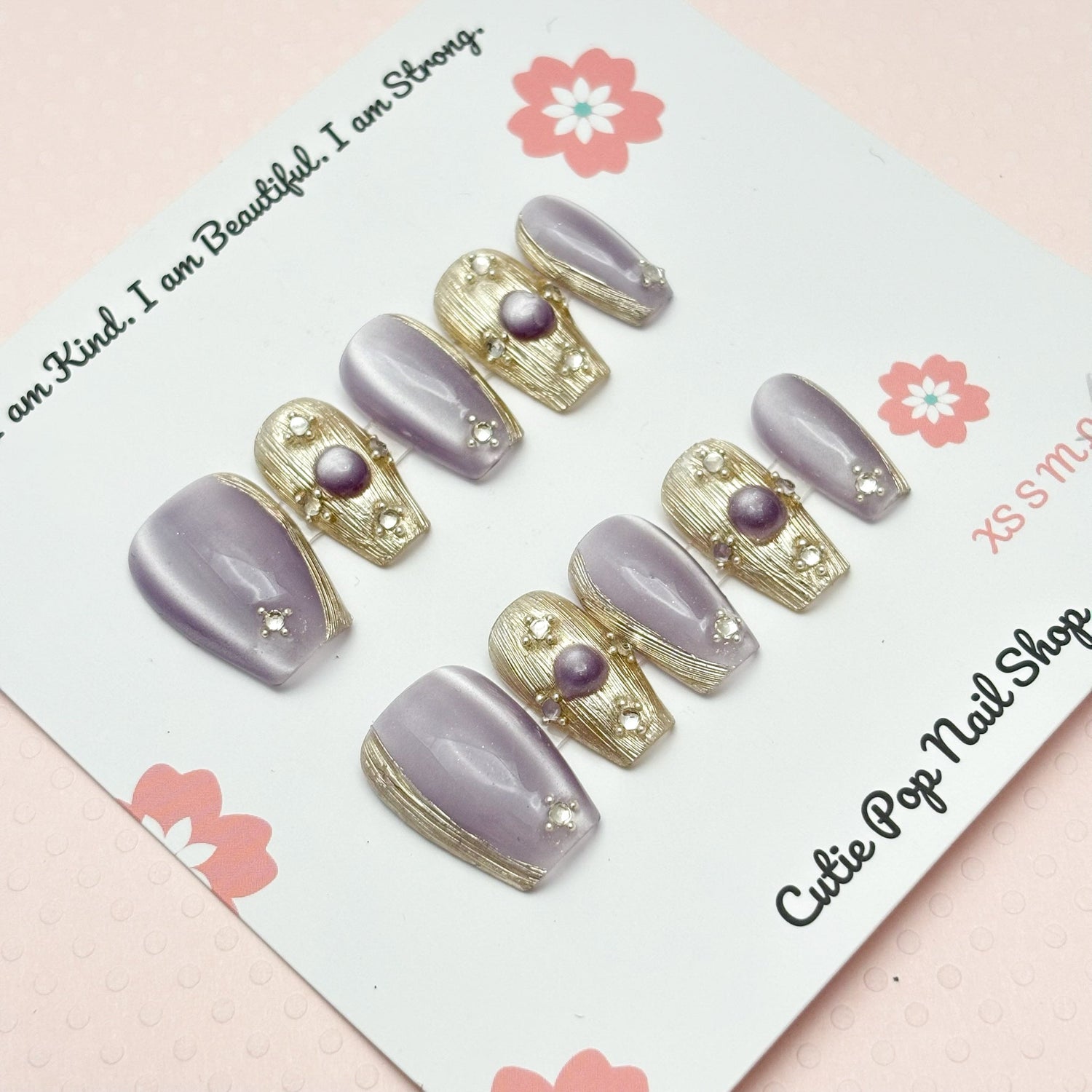 Short coffin-shaped press-on nails in purple from Cutie Pop Nail Shop, Renaissance style with a glossy finish.
