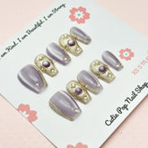 Short coffin-shaped press-on nails in purple from Cutie Pop Nail Shop, Renaissance style with a glossy finish.