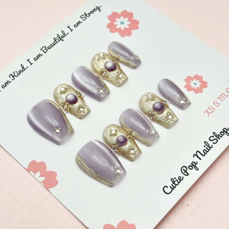 Short coffin-shaped press-on nails in purple from Cutie Pop Nail Shop, Renaissance style with a glossy finish.