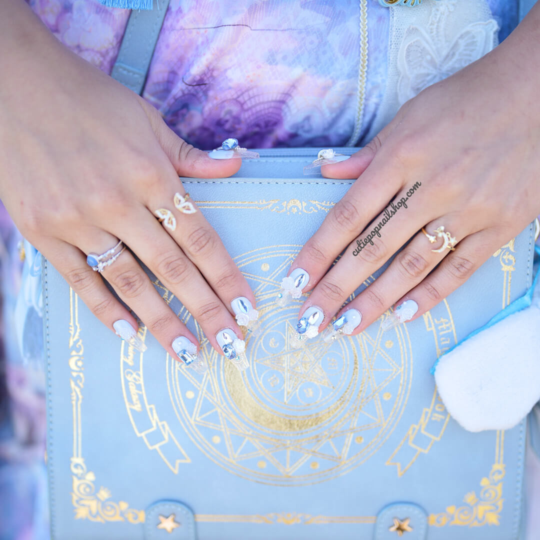Blue coffin-shaped press on nails with an elegant rose design by Cutie Pop Nail Shop, showcasing a stylish, easy-to-wear manicure.