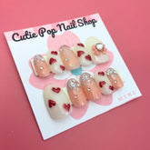 Red Hearts press-on nails by Cutie Pop Nail Shop with round shape and small medium-sized red heart designs.