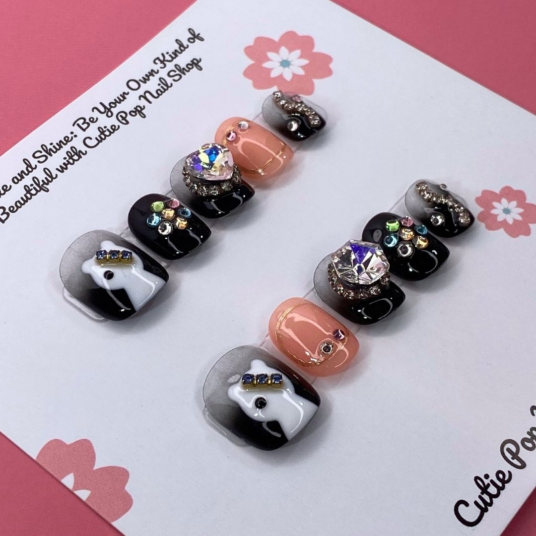 Press-on nails from Cutie Pop Nail Shop in Spooky Sparkle design with glittery black and orange Halloween-themed accents.