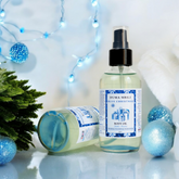Blue Christmas Body Oil by Duma Mbili LLC in a clear 4 oz bottle, featuring a vibrant blue-colored oil with festive holiday packaging.