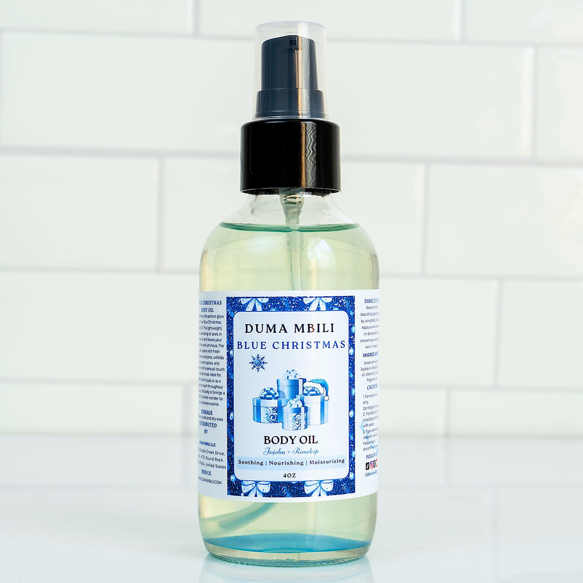 Blue Christmas Body Oil by Duma Mbili LLC in a 4 oz bottle, featuring a vibrant blue color and festive holiday packaging.