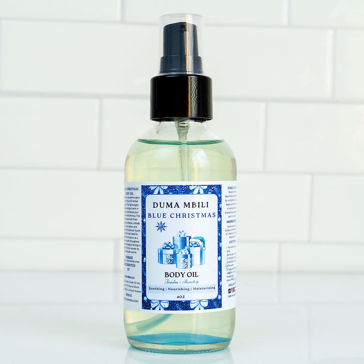 Blue Christmas Body Oil by Duma Mbili LLC in a 4 oz bottle, featuring a vibrant blue color and festive holiday packaging.