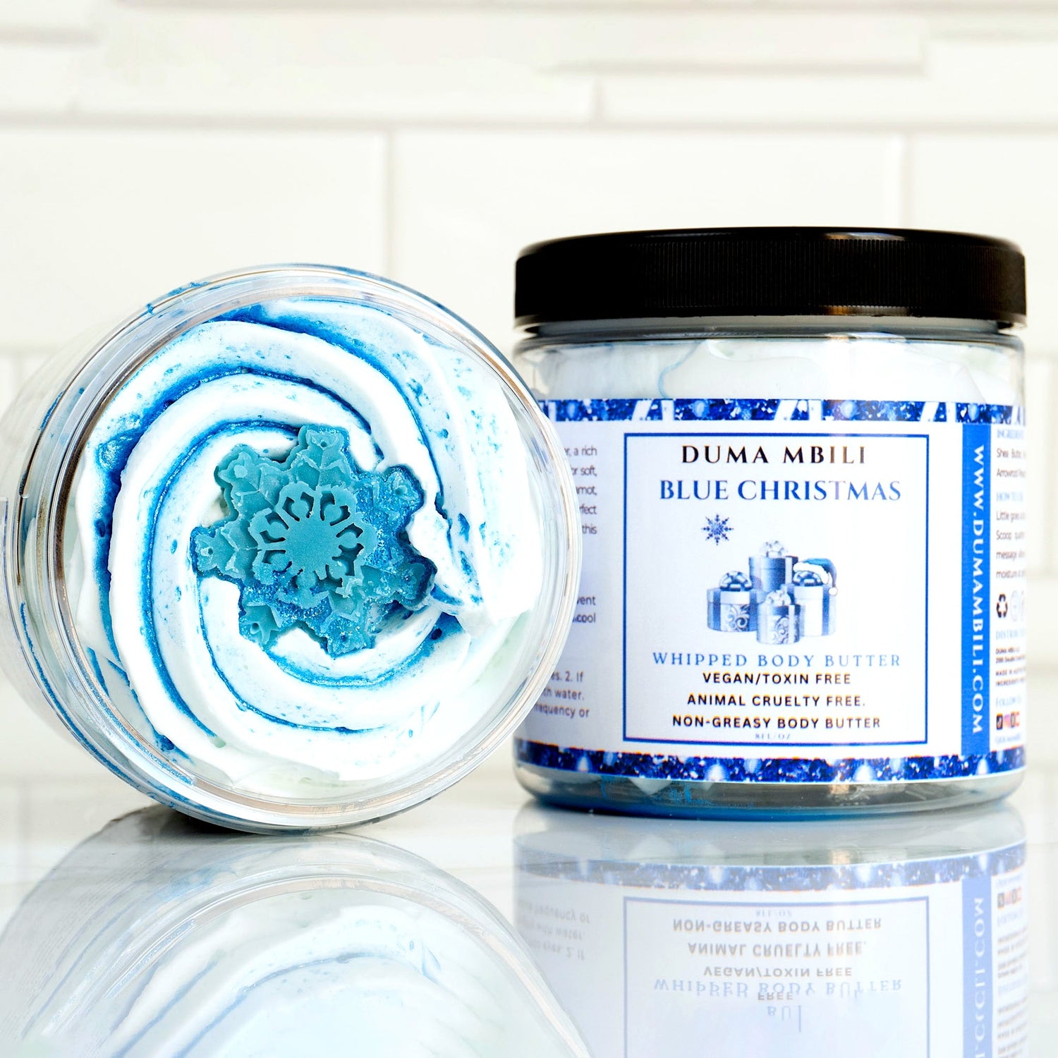 Blue Christmas whipped body butter by Duma Mbili LLC in a jar, showcasing its fluffy, creamy texture and festive holiday theme.