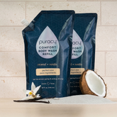Puracy citrus and sea salt acidified pH balanced body wash in a clear bottle with a flip-top cap, showing fresh citrus slices.