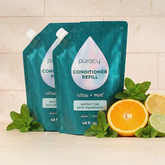 Puracy conditioner with citrus mint scent, sulfate-free and silicone-free, shown in a sleek bottle with fresh citrus and mint leaves