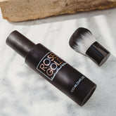 Rose Gold Sunless facial tanning mist in clear spray bottle, hydrating facial water for natural sunless tanning.