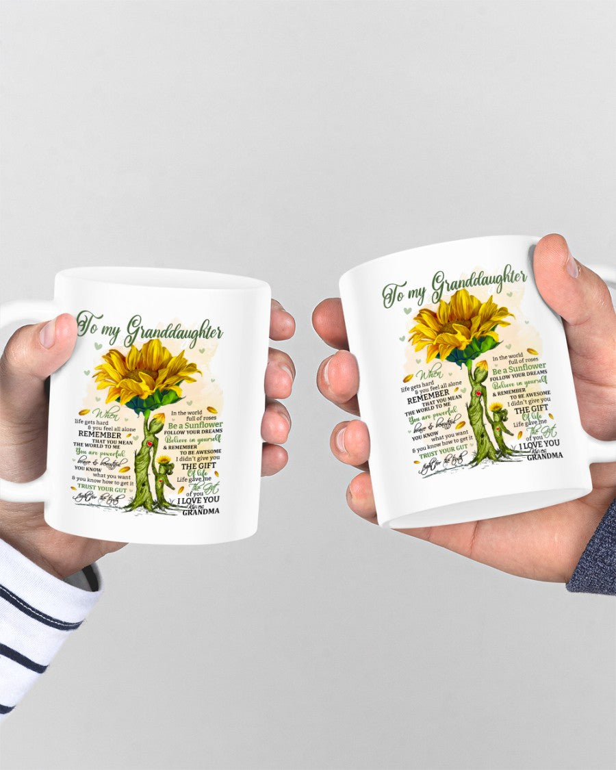 11oz ceramic mug with "To Granddaughter" message from TEELUVS.COM, featuring a colorful floral design on a white background.