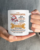 Teeluvs.com 11oz ceramic mug with "To Granddaughter" message, ideal gift from grandma, featuring colorful design and handle.