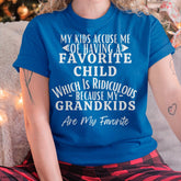 Black TEELUVS.COM husband US 00 T-shirt with humorous "My kids accuse me of having a favorite child" print, worn by a person.