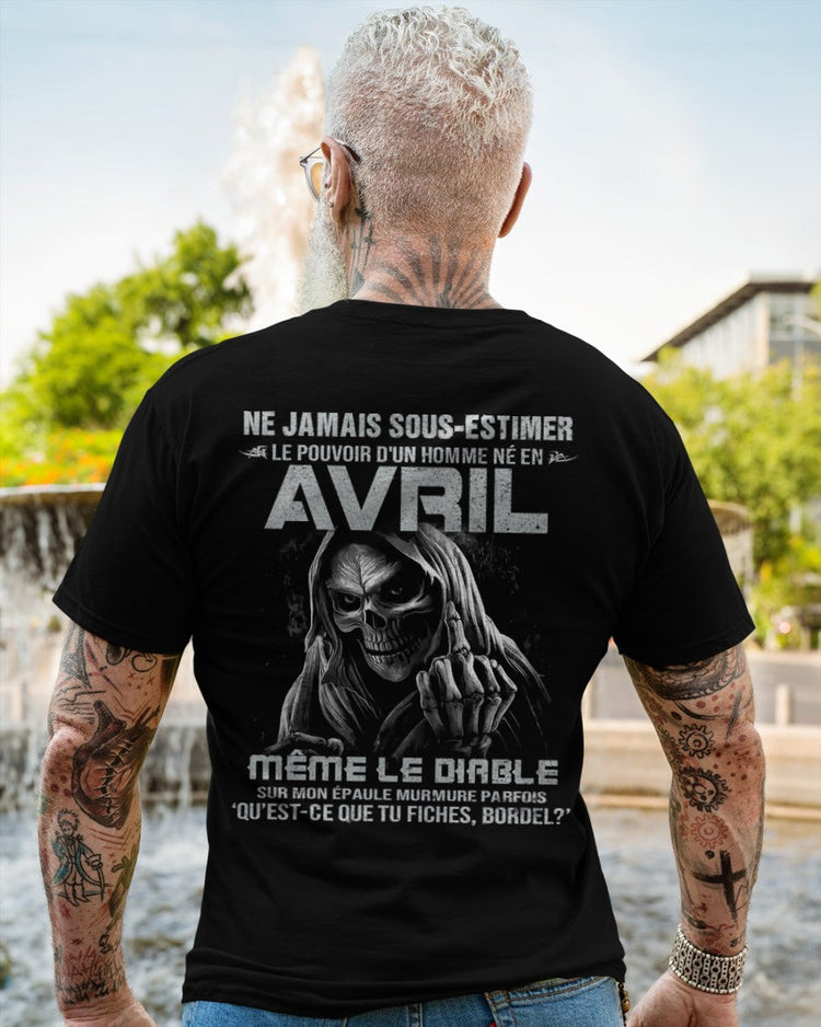 Black T-shirt featuring the phrase "Ne jamais sous-estimer le pouvoir d’un homme né en avril" in bold white text, male fit.