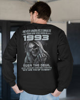 Black TEELUVS.COM T-shirt featuring "Never Underestimate Us 1993" text, short sleeve and casual fit.
