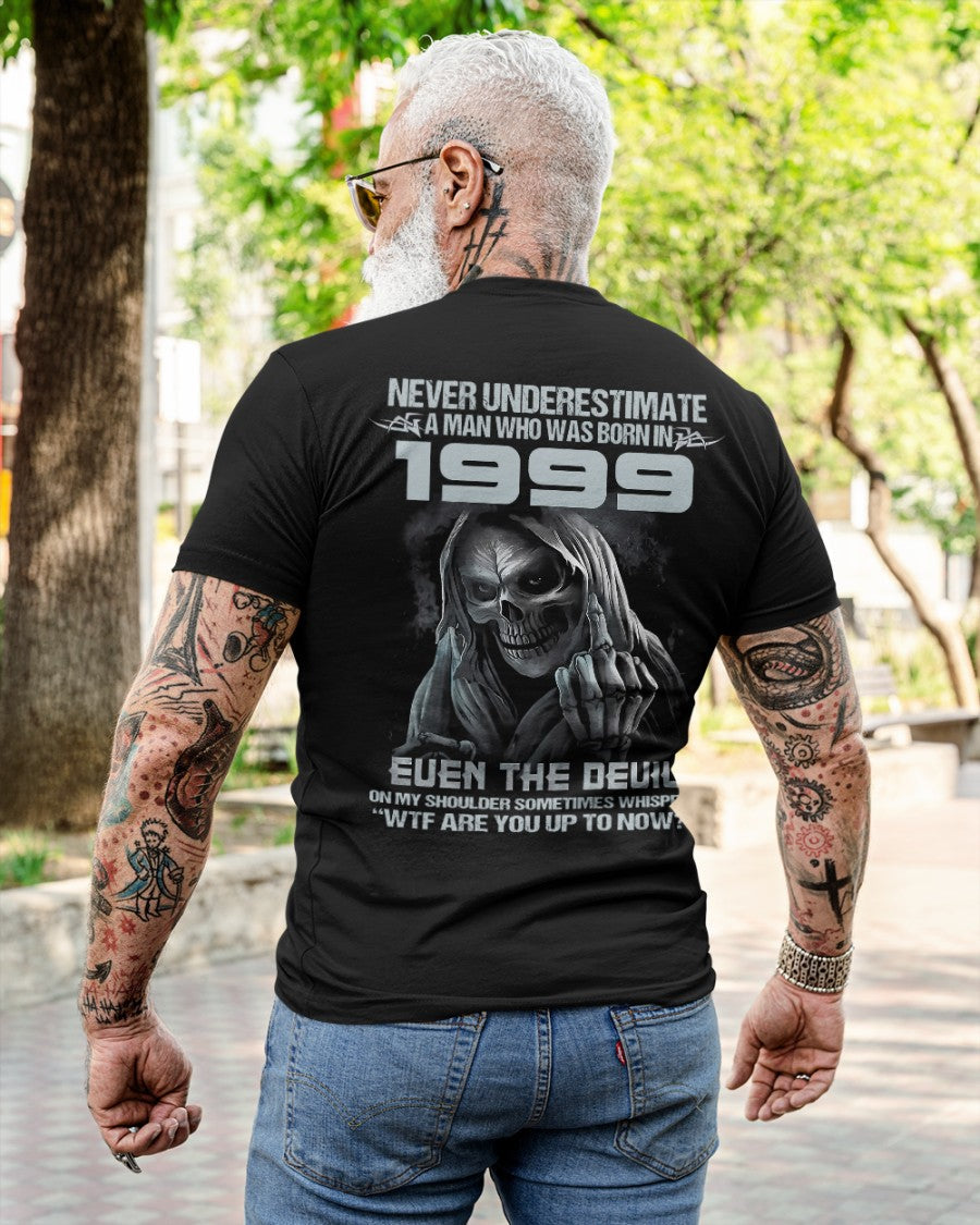 Black T-shirt from TEELUVS.COM with "Never Underestimate Us 1999" printed on the front, displayed on a mannequin.