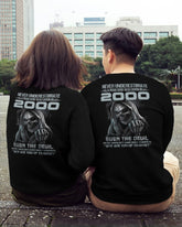 Black T-shirt for men with "Never Underestimate US2000" print, from TEELUVS.COM, displayed on a male model.
